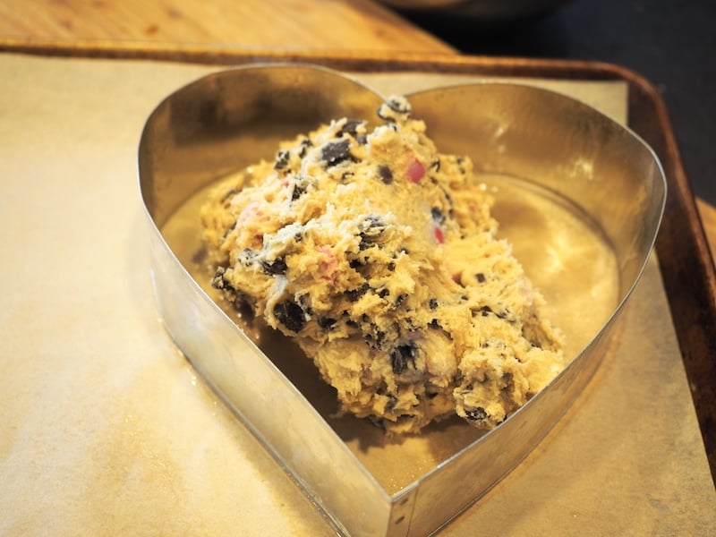 Cookie dough in heart form on sheet pan. 