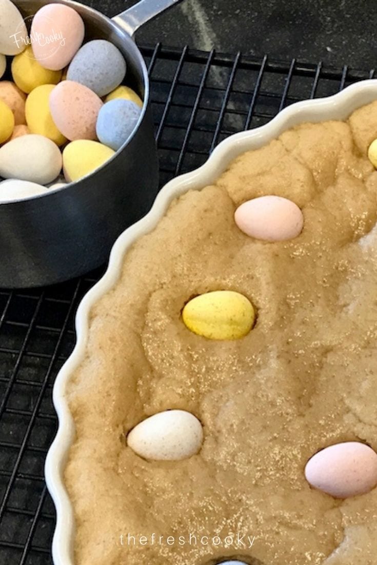 Prebaked giant cookie cake with cadbury Easter chocolates pressed into the dough. 