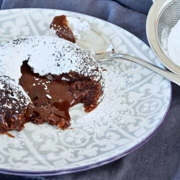 Chocolate lava cake oozing on a pretty plate.