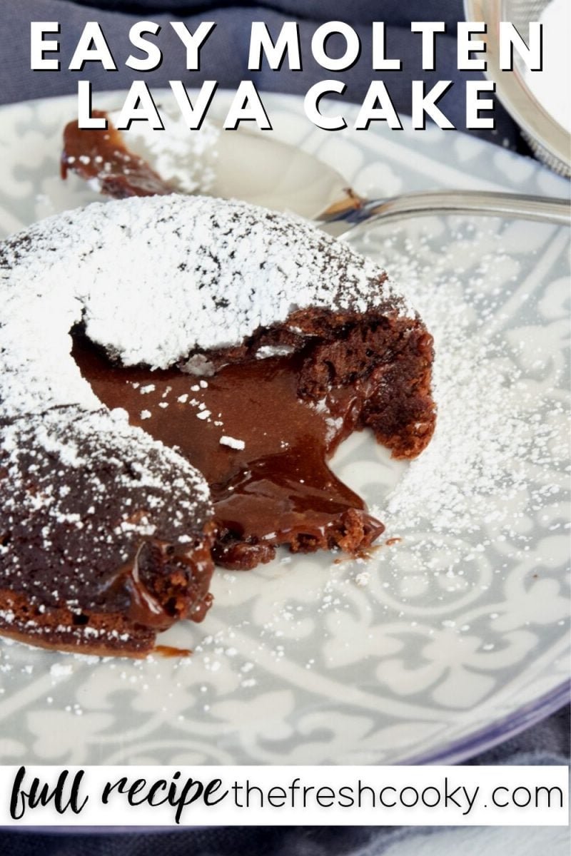 Pinterest Image for Easy Molten Lava Cake with image of cake gooey and oozing lava on patterned plate with spoon behind, dusted with powdered sugar