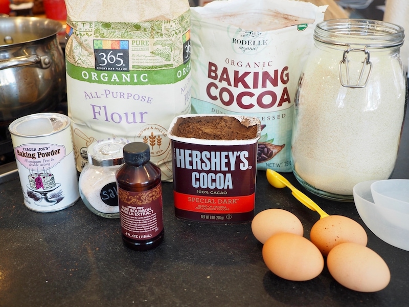brownie ingredients,left to right. Baking powder, all purpose flour, baking cocoa, natural sugar, eggs, cocoa, vanilla and salt