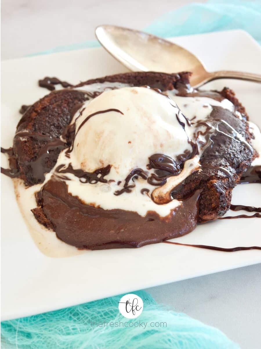 Easy Lava Cake Recipe on square plate oozing chocolate with scoop of melting vanilla ice cream