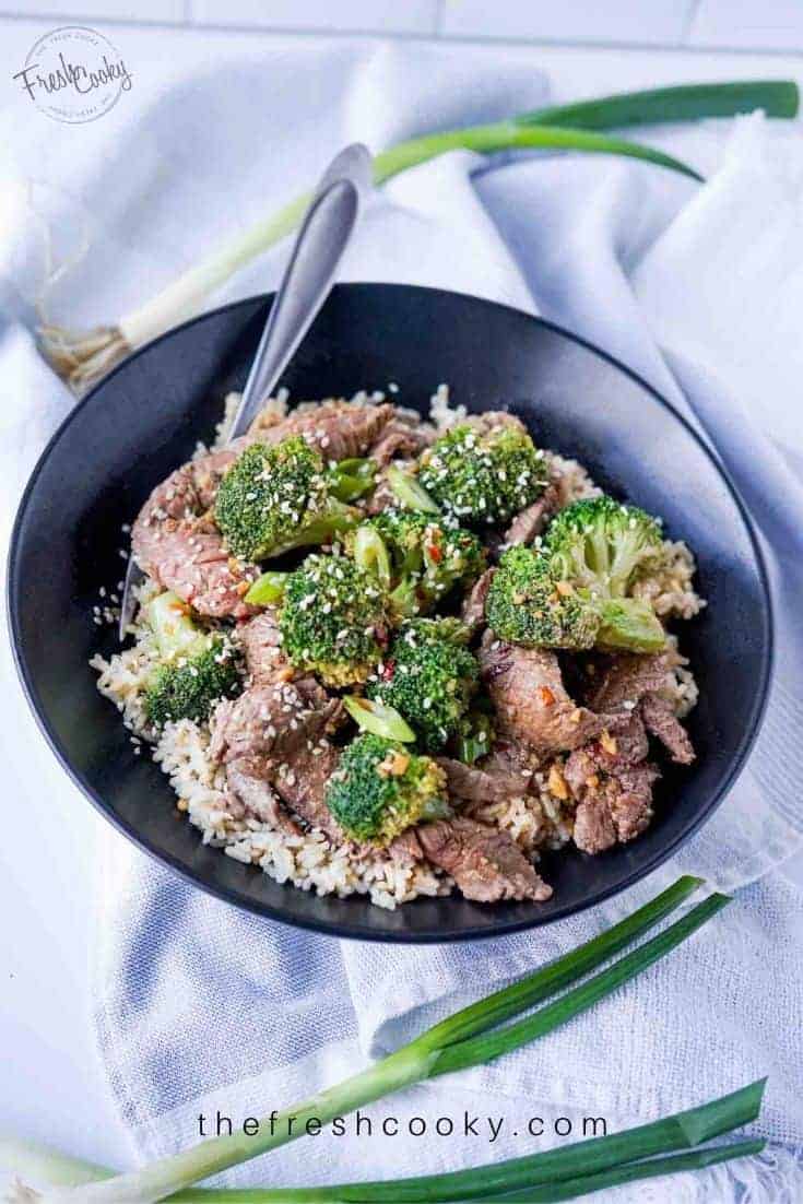 Pin with black bowl filled with brown rice, and healthy beef and broccoli recipe. 
