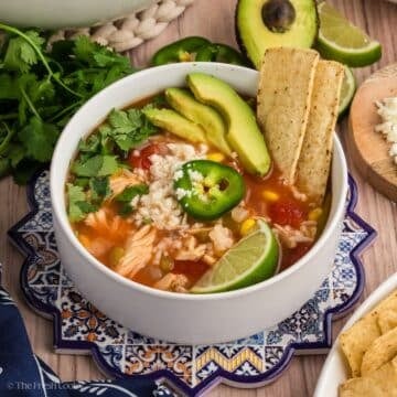 Chicken tortilla soup loaded with avocado, lime and cheese.