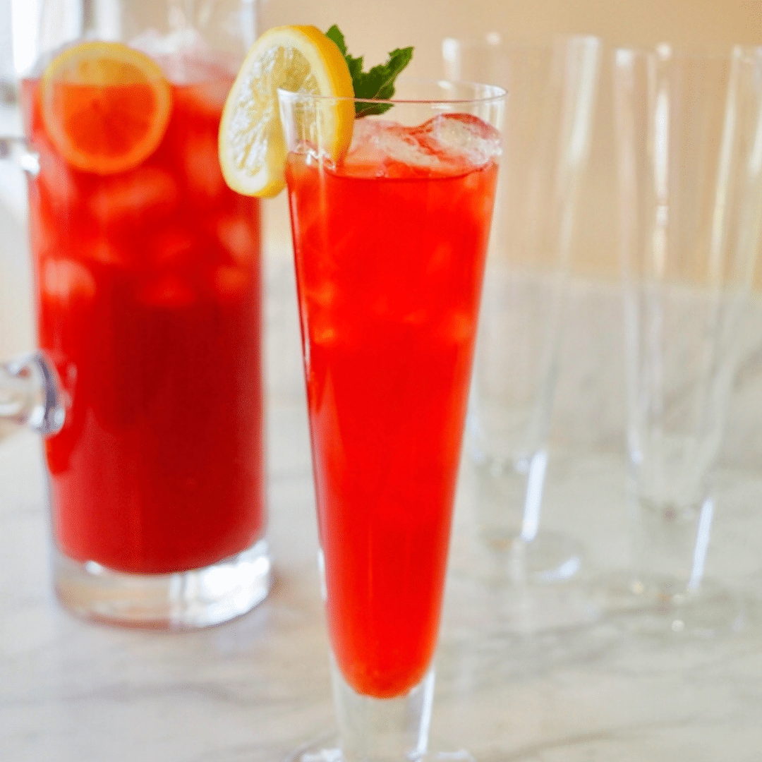 Pitcher and glass filled with bright red, flavorful texas tea.