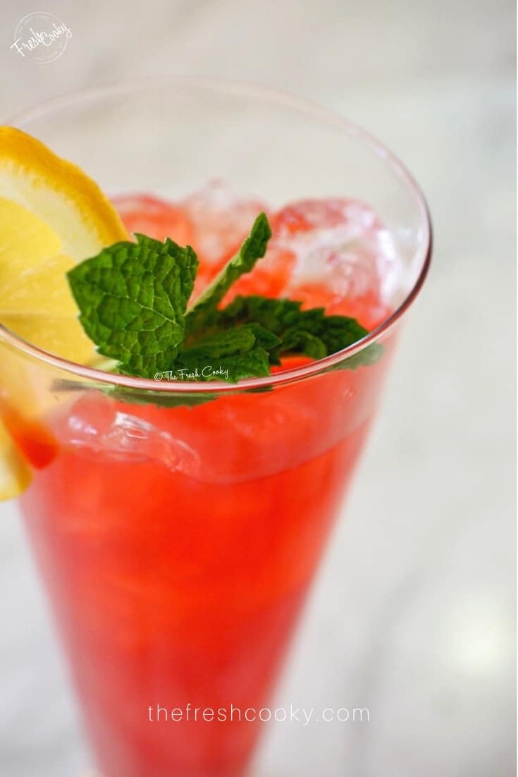 Image close up of Texas Tea in a tall glass with crushed ice a sprig of mint and a lemon wheel. 