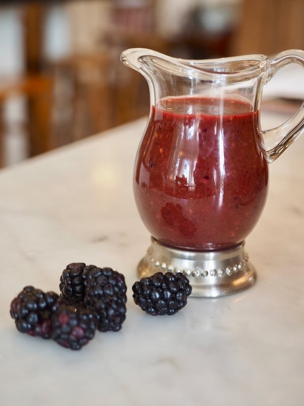 Small vase of blackberry balsamic vinaigrette.