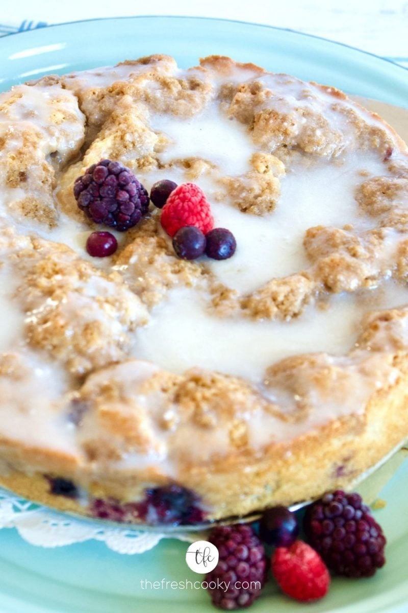 Close up of Blueberry Crumb Cake with frozen blackberries, raspberries and blueberries on top.