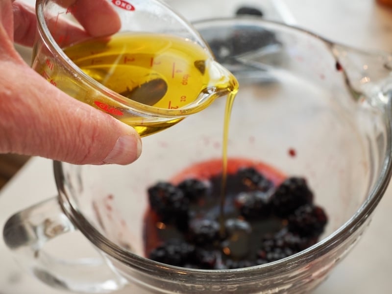 Pouring olive oil for dressing Blackberry Grilled Chicken Salad 