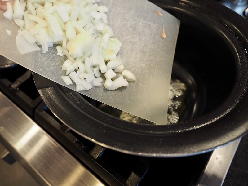 chopped onions falling into crockpot to be sauted. www.thefreshcooky.com