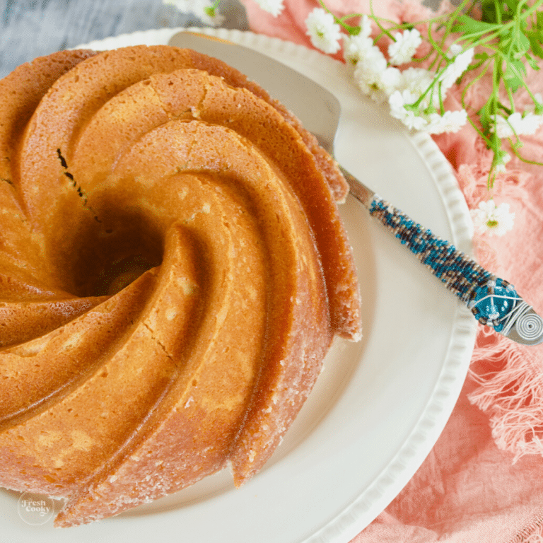 Old Fashioned Butter Pound Cake on platter with flowers.