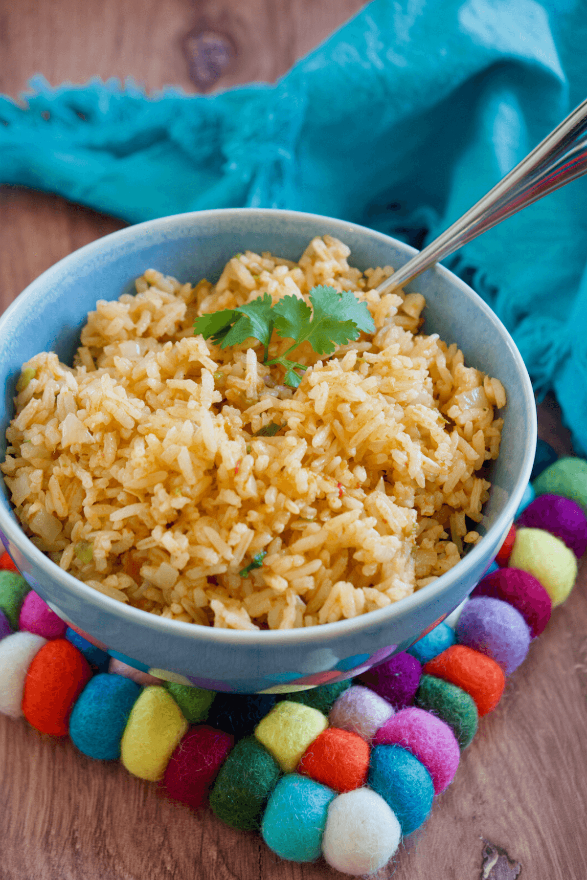 Best vegetarian spanish rice recipe in blue bowl with colorful trivet.