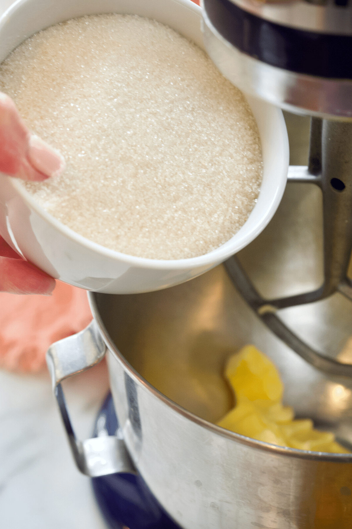 Adding sugar to butter in stand mixer for butter cake.