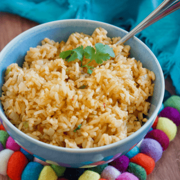 Best vegetarian spanish rice recipe in blue bowl with colorful trivet.