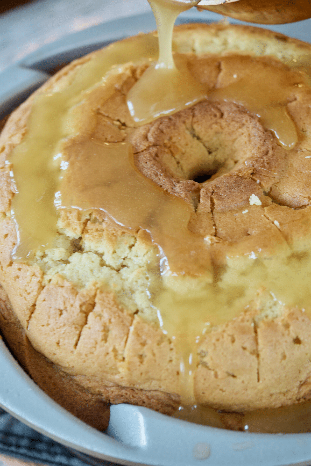 Pouring vanilla sauce over the warm cake. 