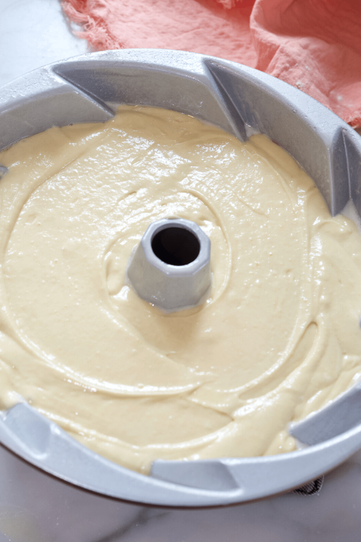 Smooth cake batter and tap to settle into bundt pan. 