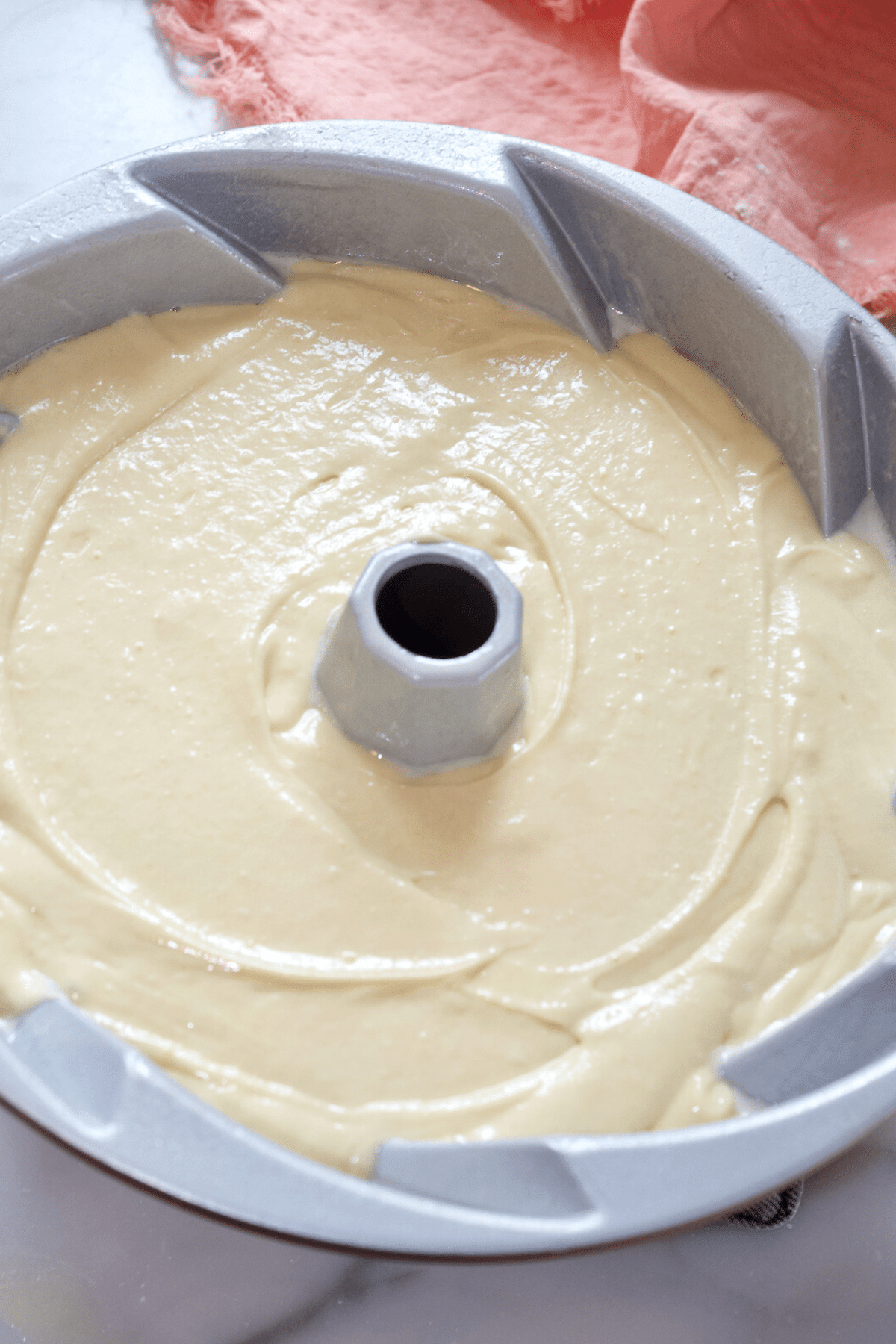 Smooth cake batter and tap to settle into bundt pan.