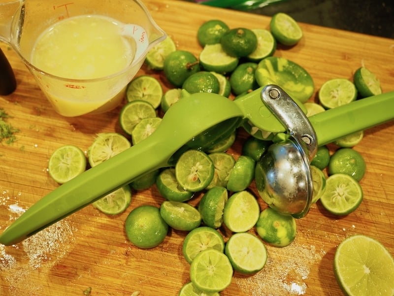 pile of juiced limes limes and juicer.