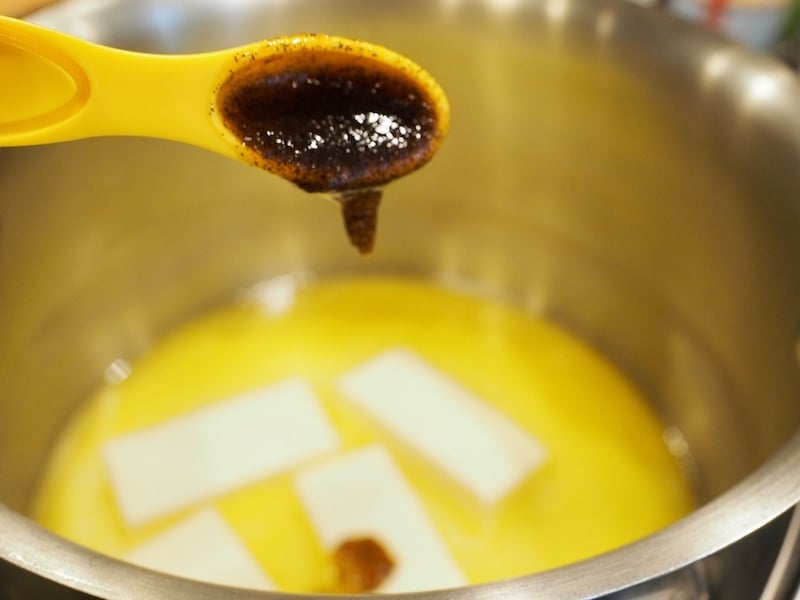  adding vanilla bean paste to melting butter in saucepan. 
