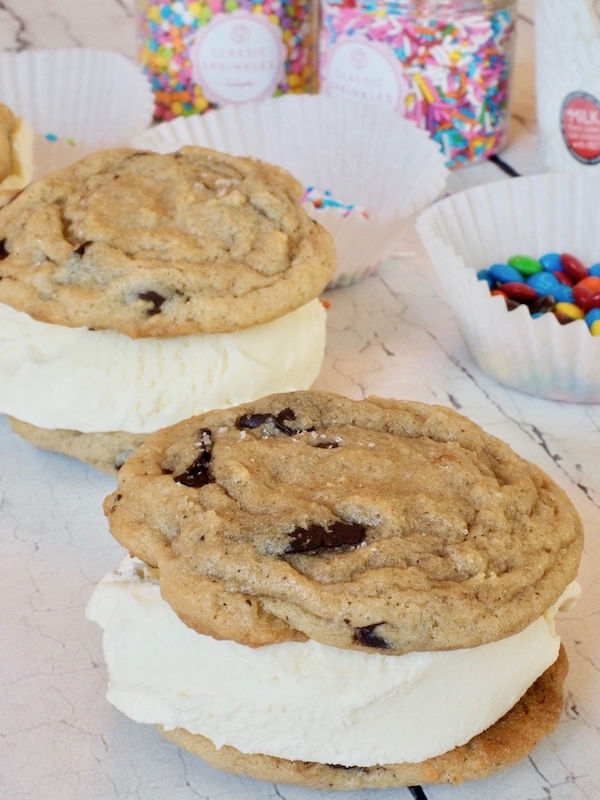 Cool and creamy ice cream, sandwiched between two chewy Chocolate Chip Cookies, dipped in sprinkles no less -- the very essence of summertime! #thefreshcooky #icecreamsandwich #chocolatechipcookies #icecream #dessert