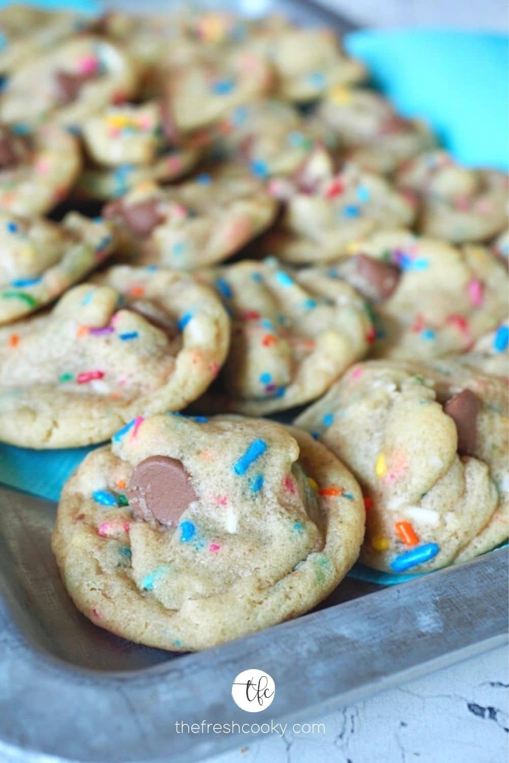 Galvanized tray filled with stacked brightly colored funfetti cake mix chocolate chip cookies.