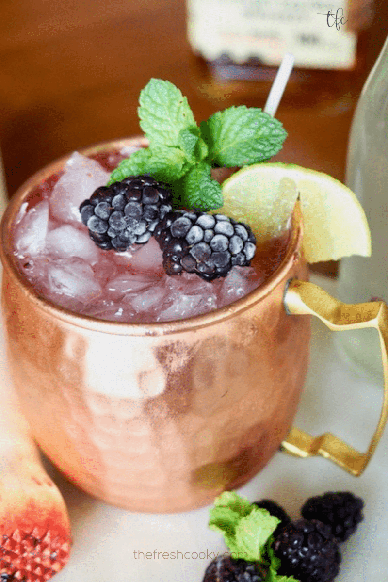Blackberry Moscow Mule in copper mug with lime, blackberries and mint.