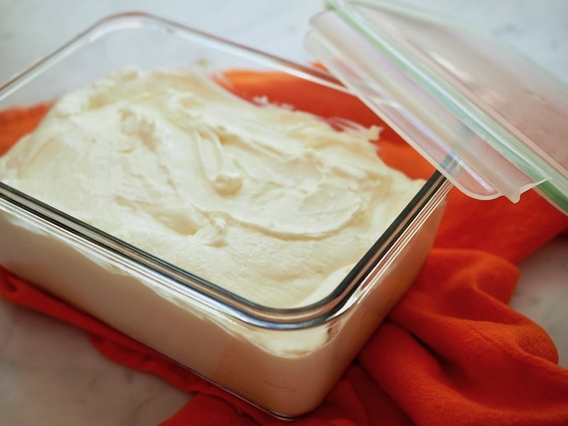 rectangle glass storage container filled with creamy Greek yogurt with an orange napkin. thefreshcooky.com 
