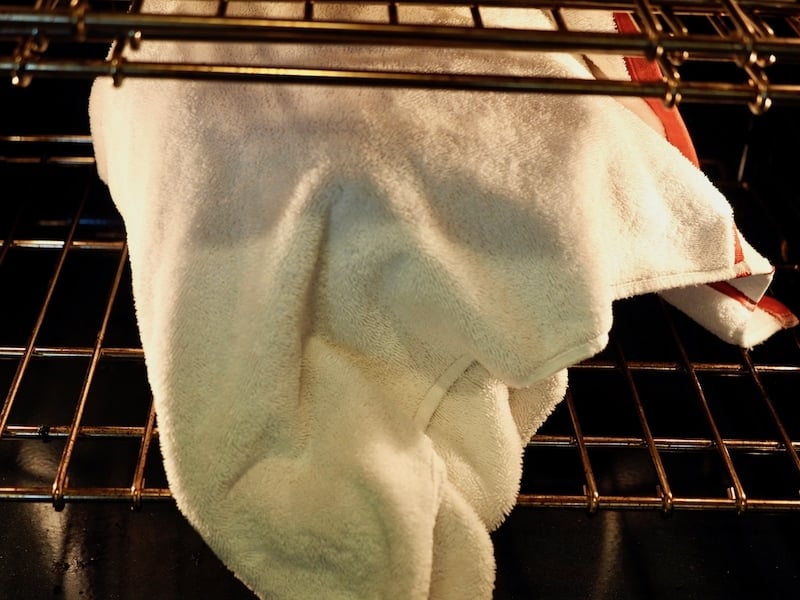 Towel wrapped around mixing bowl in oven with lights. thefreshcookyy.com