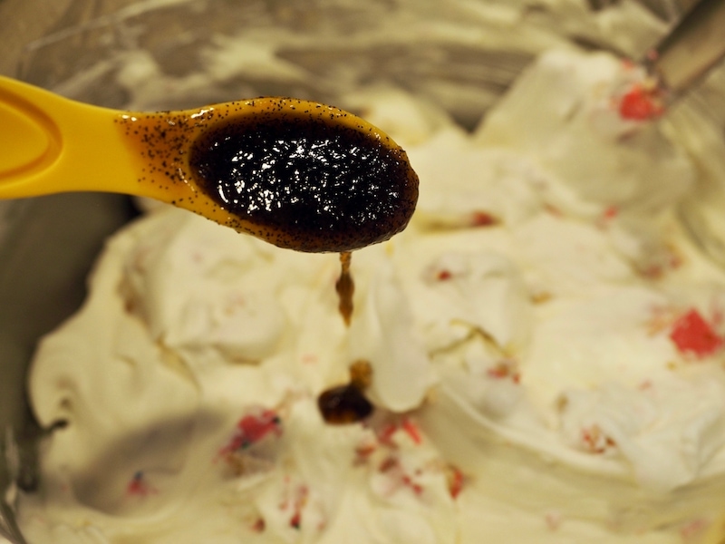 Adding vanilla bean paste to whipped cream mixture for Circus Animal Ice Cream.