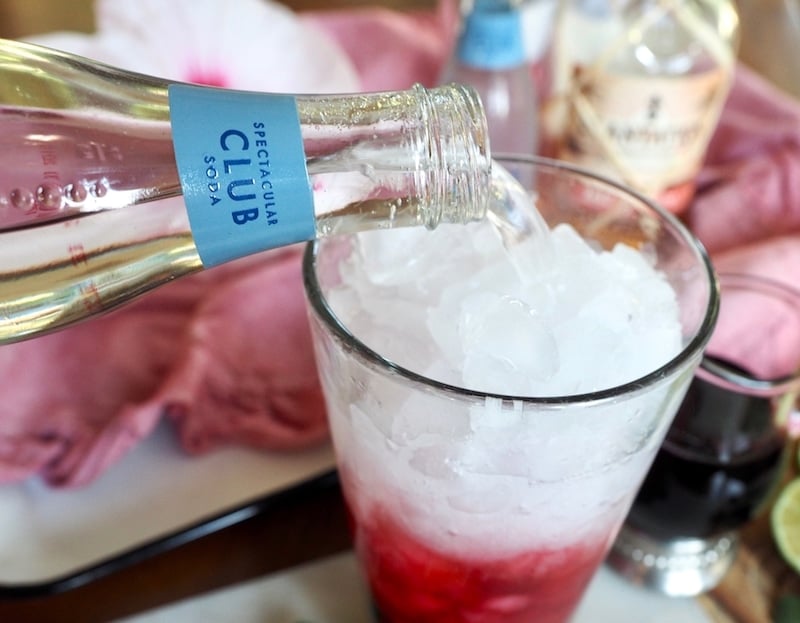 Pouring club soda into tall glass