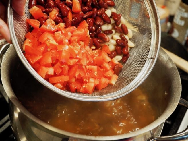 adding beans, fresh tomatoes to bacon beef minestrone soup