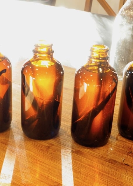 Vanilla in Amber bottles with sunlight from back on cutting board.  