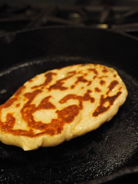 This recipe for restaurant style, homemade Naan bread is like bringing a taste of India into your kitchen. Learn how to make this simple flatbread with my step by step instructions. #thefreshcooky #naan #bread #indianfoods #authentictaste #restaurantstyle #butterchicken #curry