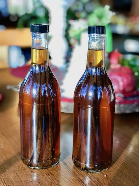 Homemade Vanilla Extract two bottles in the brewing stage on a table.