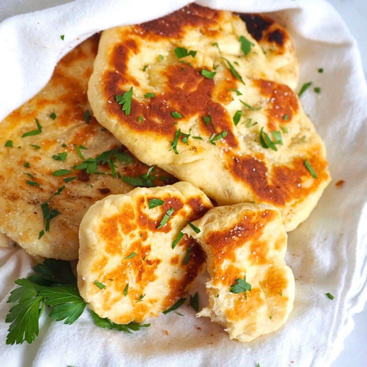 Authentic Naan bread wrapped in a tea towel to keep warm.