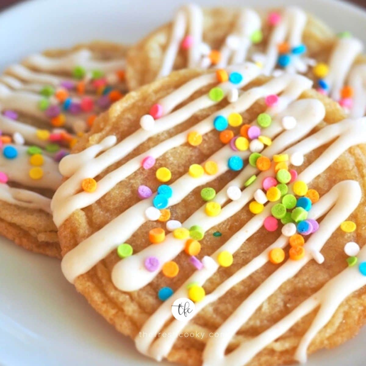 square image of pan banging sugar cookies, a large wrinkly cookie with to die for brown butter glaze and sprinkles.