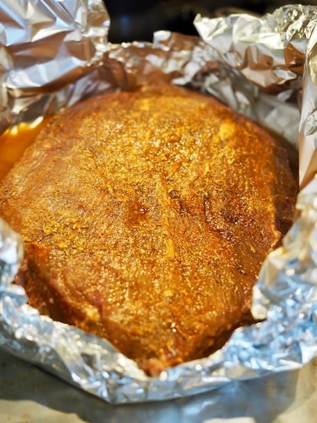 A seasoned slab of beef brisket with orange juice and liquid smoke in an aluminum foil pouch. BBQ Beef Brisket | www.thefreshcooky.com