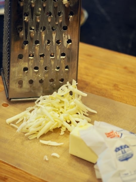 Grated butter on cutting board with box grater in background