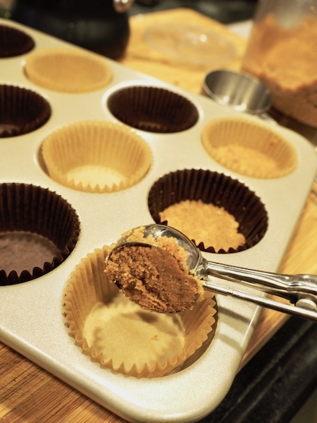 scooping crust mixture into cupcake tin for Mini Chocolate French Silk Pies | www.thefreshcooky.com