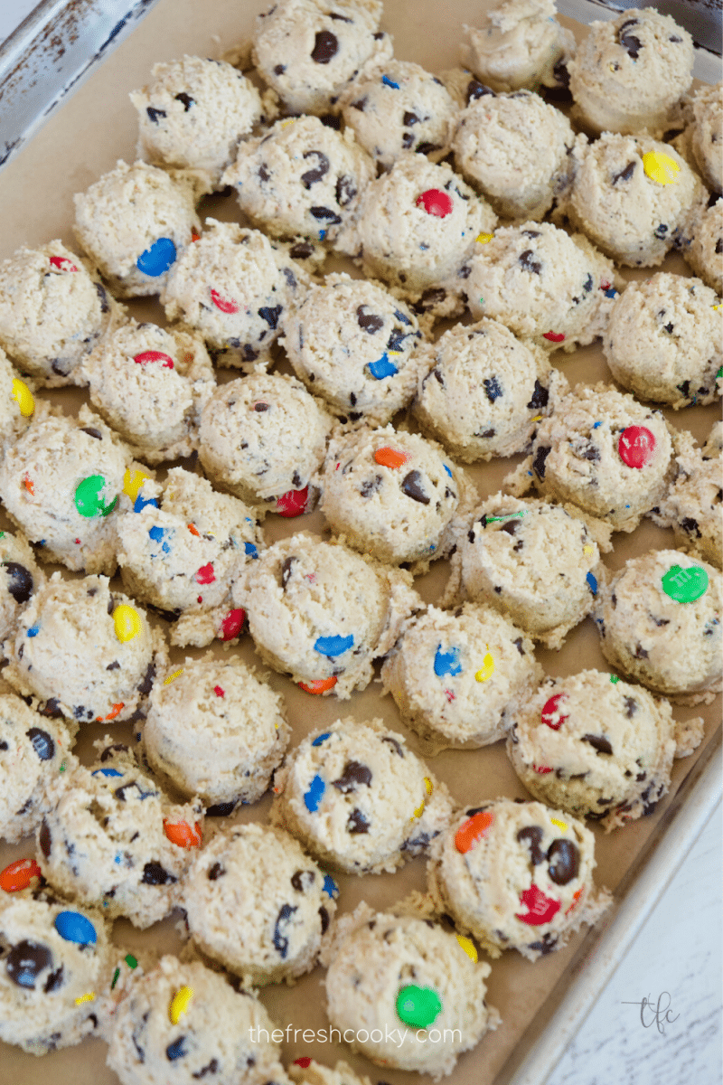 m & m chocolate chip cookies dough ready to freeze on prepared baking sheet.
