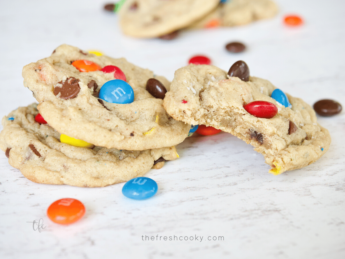 Chocolate Chip Cookies laying on table with bite taken out of one.