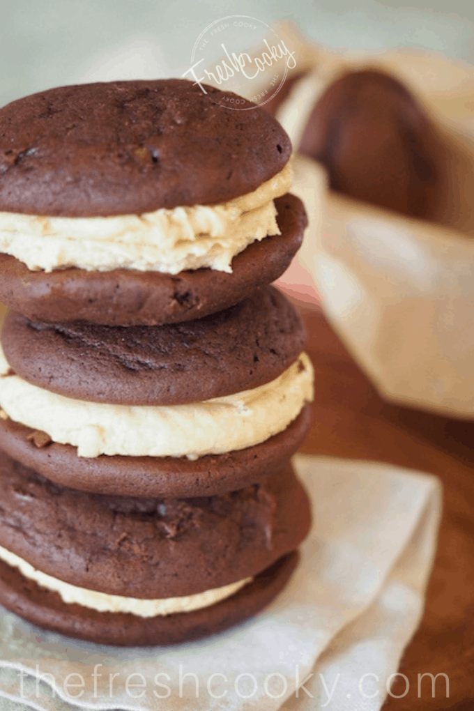 Stack of three Chocolate Fluffernutter Whoopie Pies on parchment. 