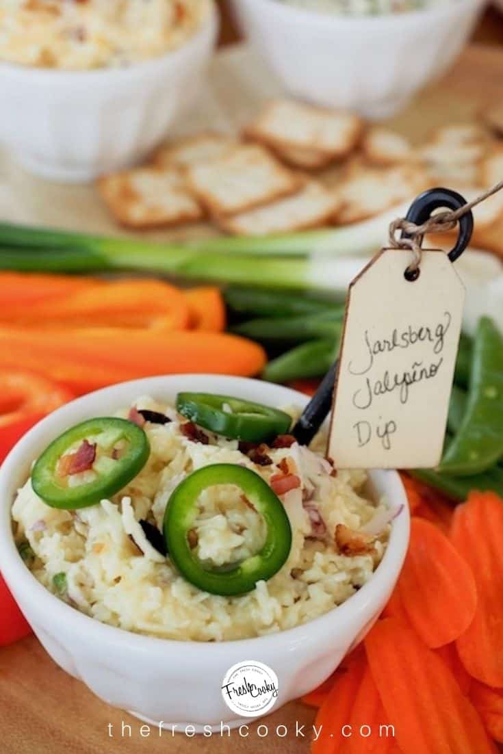 White bowl full of jarlsberg cheese dip with jalapenos. 