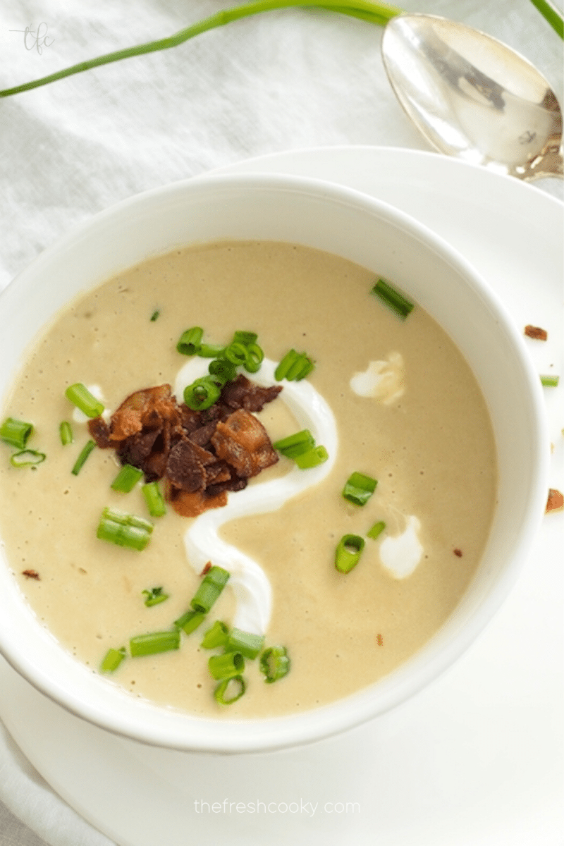 Pin for Instant Pot Potato Leek Soup with top down shot of white bowl filled with creamy potato soup topped with bacon, chives and sour cream.