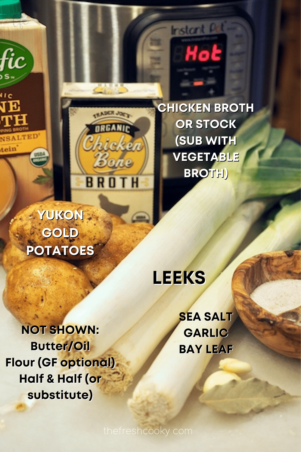 Image of Instant Pot chicken broth, leeks, potatoes, bay leaf, garlic and salt ingredients for Instant Pot Potato Leek Soup.