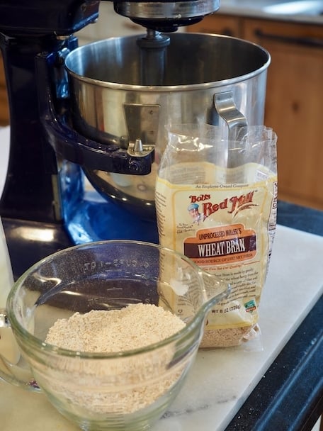 Cobalt Blue mixer in background with bag of wheat bran and mixing bowl with whole wheat flour and bran. | www.thefreshcooky.com