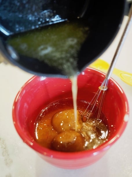 Pouring butter into small red bowl with mini whisk and glaze ingredients. | www.thefreshcooky.com