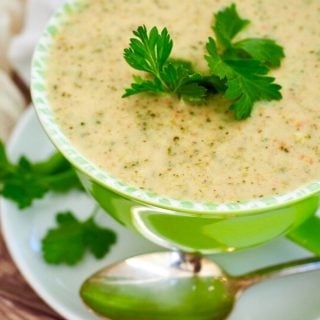 Top down image of large bright green bowl filled with creamy broccoli cheese copycat Panera soup.