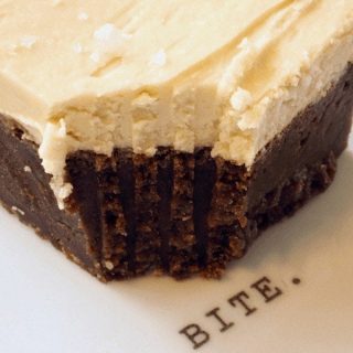 Milk Stout Brownies with bite taken out on a white plate that says "bite"