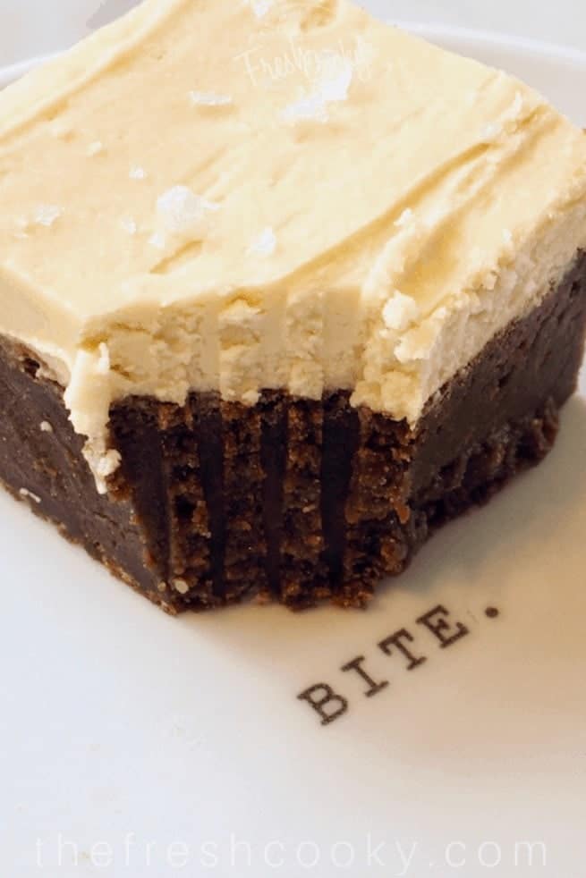 Milk Stout Brownies with bite taken out  on a white plate that says "bite"